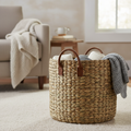 Woven seagrass storage basket with leather handles in a cozy living room